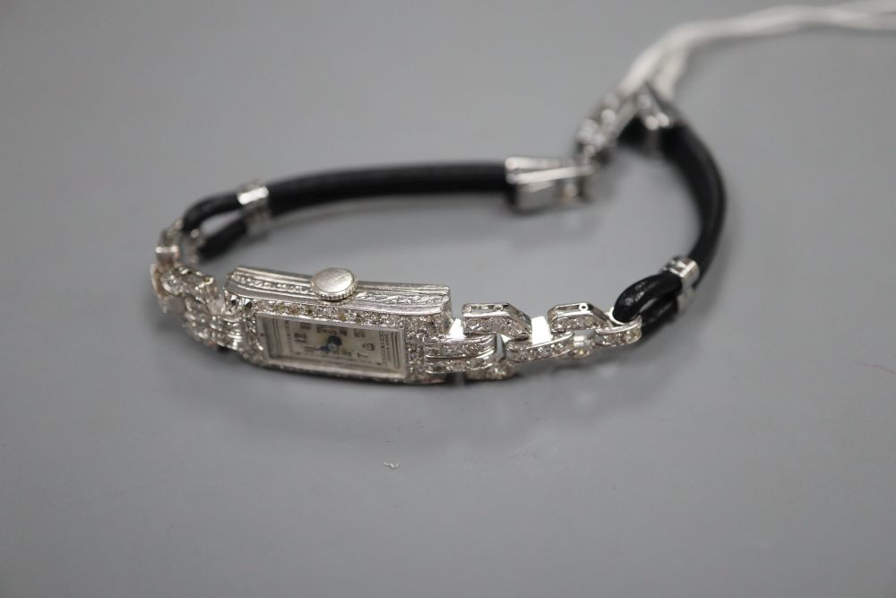 A ladys white metal (stamped platinum) and diamond set cocktail watch, on twin leather strap with steel clasp, approx 18cm,